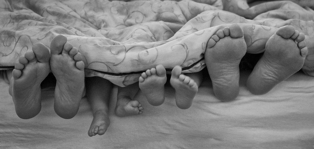 two sets of parents feet with their children's feet between them